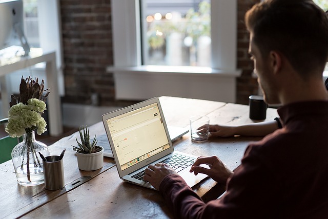 Seven Ways To Make Your Office Happier - Man Working On Laptop On Desk