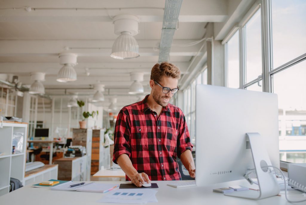 man working on desktop computer in modern workplace. 