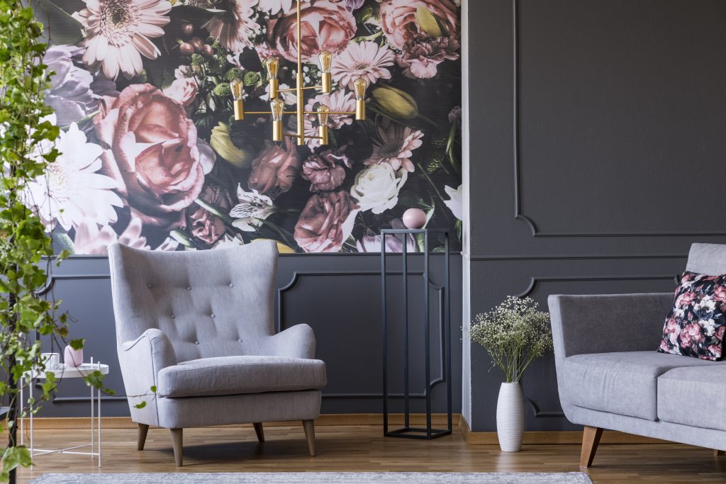 Grey armchair in living room with botanical wallpaper