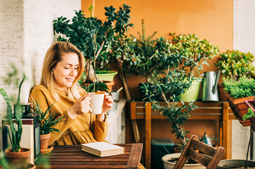 Women drinking hit drink surrounded by plants succulants