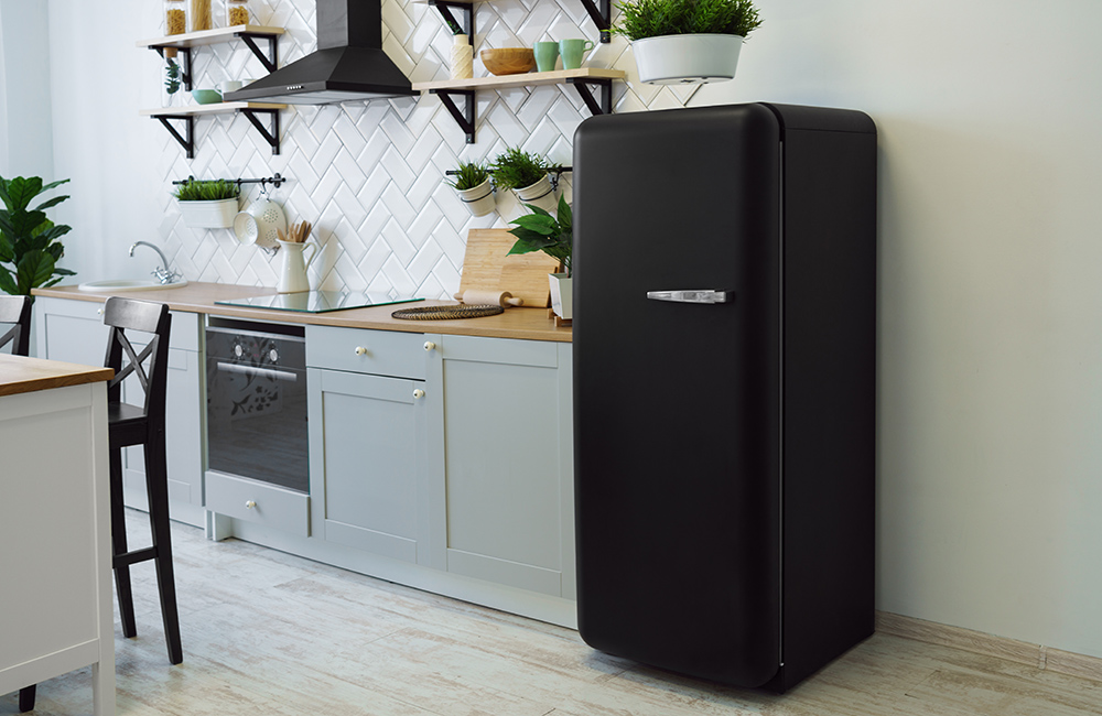 Retro style black fridge in gray wooden kitchen