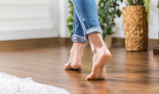 Women in blue jeans walking across wooden flooring