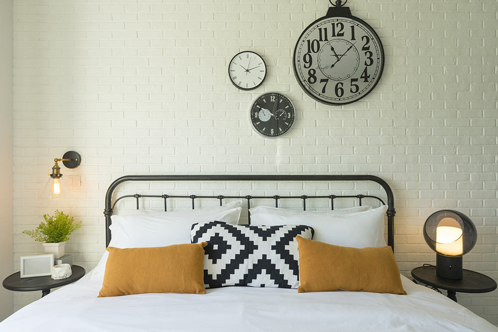 Metal bed with three decorative clocks on the wall