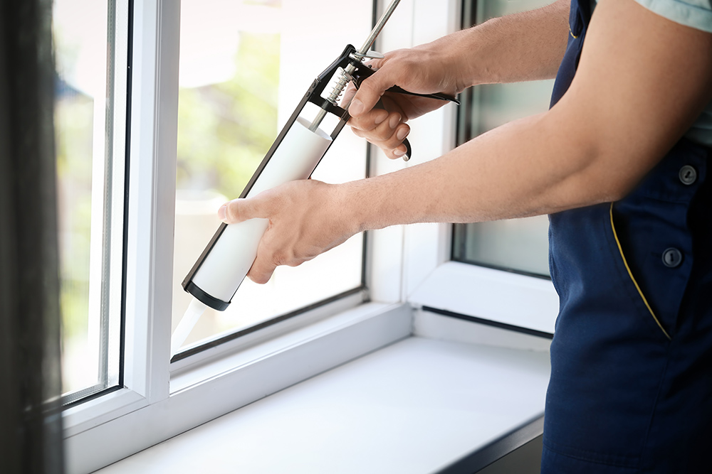 Man sealling new windows