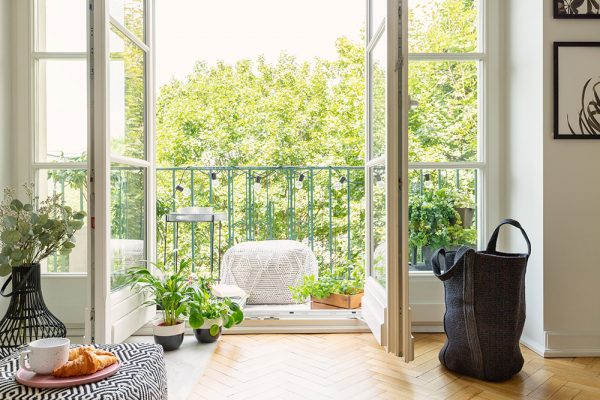 Apartment with wooden flooring leading to french doors and balcony