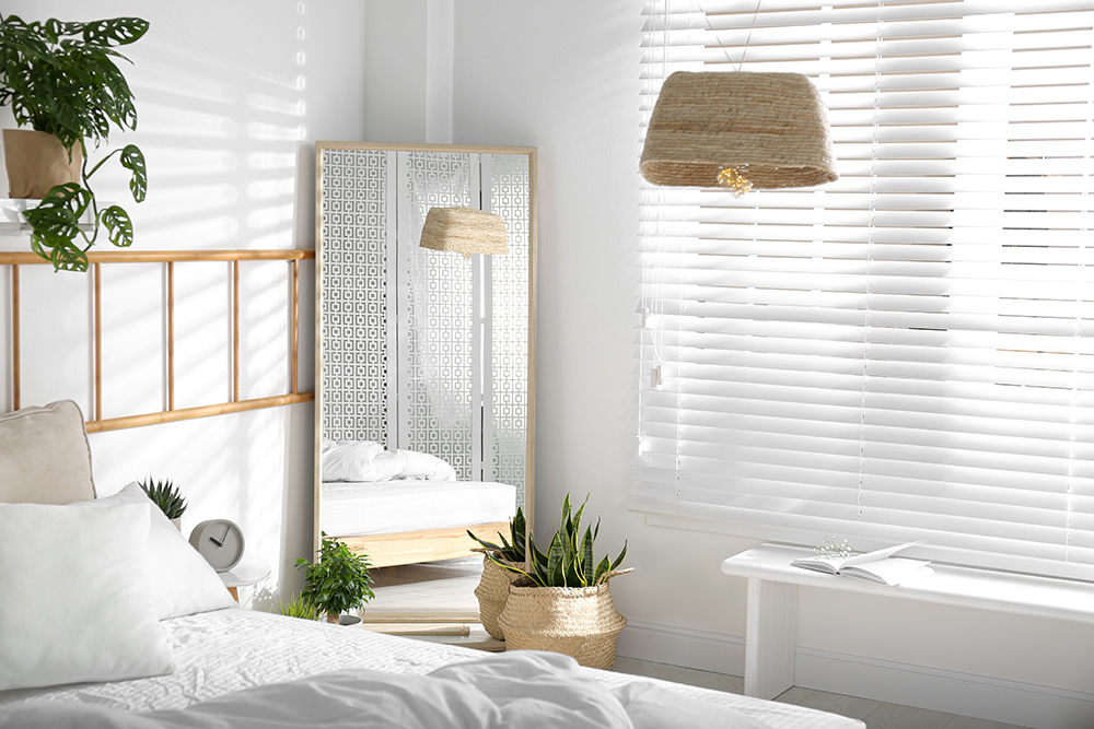 White bedroom with large mirror adding light and size to the room