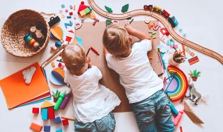 Children crafting and drawing with toys on the floor