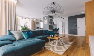 Lounge with wooden flooring, large blue L shaped sofa