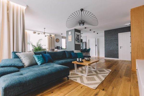 Lounge with wooden flooring, large blue L shaped sofa