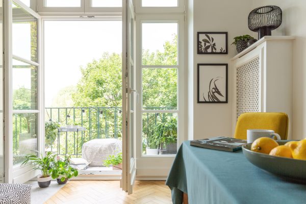 Apartment with a balcony decorated with plants. Bowl of lemons on a table.