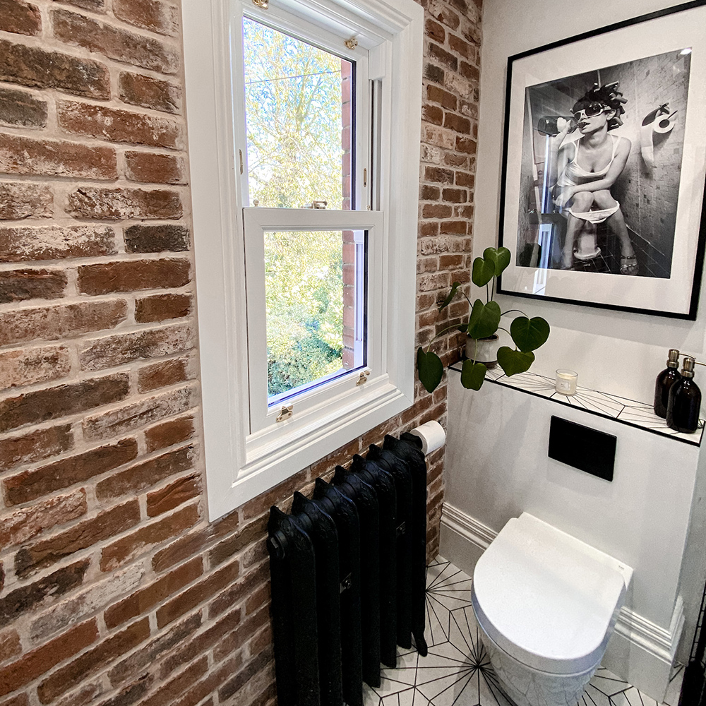 Toilet with black cast iron radiator and brick slip walls