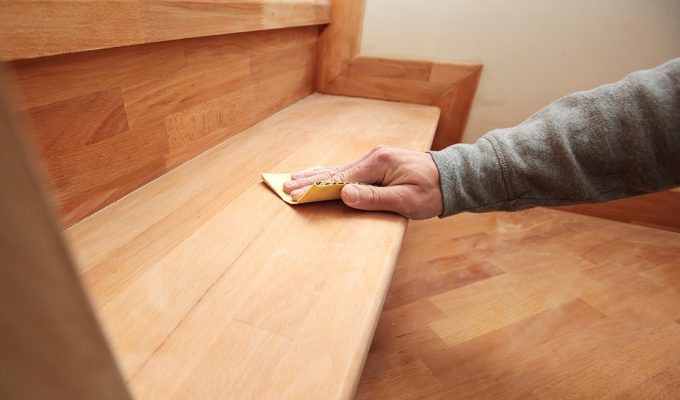 Wooden staircase being sanded by hand