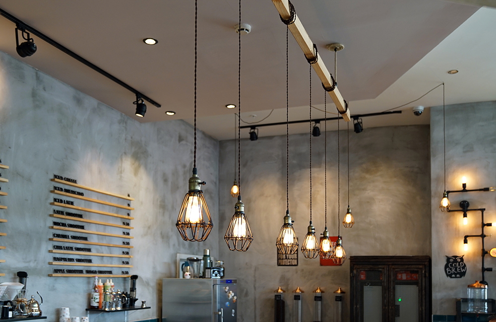 Bear concrete walls and exposed stylish lighting in cafe/restaurant