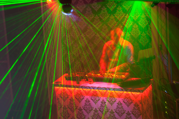 Dj usind decks surrounded by light show