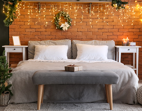 Bedroom with grey bed, Christmas Tree and Christmas lights
