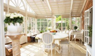 Large conservatory with ceiling blind, tiled flooring and ornate table and chairs