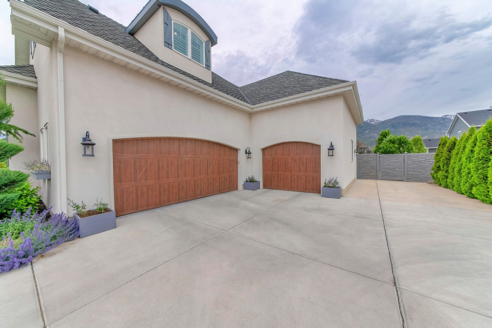 Garage with two wooden doors and concrete driveway